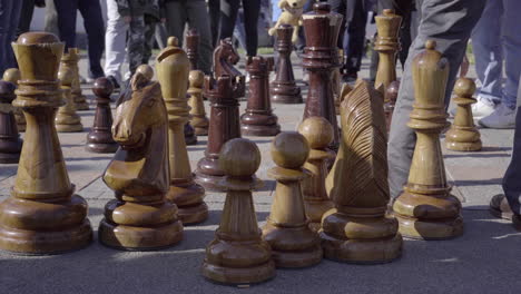 People-playing-and-watching-giant-chess-strategy-game-in-public-park-of-Lugano-4k
