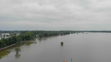 4K-Luftaufnahmen,-Die-Rückwärts-Fliegen,-Zeigen-Die-Aufnahme-Einer-Schule-Auf-Der-Majuli-Flussinsel,-Die-Von-Den-Überschwemmungen-Des-Brahmaputra-Monsuns-überschwemmt-Ist