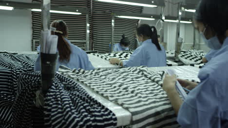 Toma-En-Cámara-Lenta-De-Trabajadoras-De-Fábrica-Haciendo-Un-Control-De-Calidad-De-Muestras-Textiles-En-Una-Fábrica-En-China