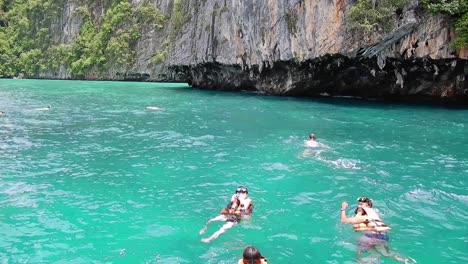 Tourist-people-swimming-and-snorkeling-in-crystal-clear-water-at-Maya-bay,-Phi-Phi-Leh-island