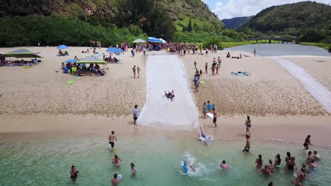 Drohnenschuss-Folgte-Einigen-Kindern,-Die-Versuchten,-Eine-Künstliche-Rutsche-In-Der-Waimea-Bay-Hinunterzurutschen