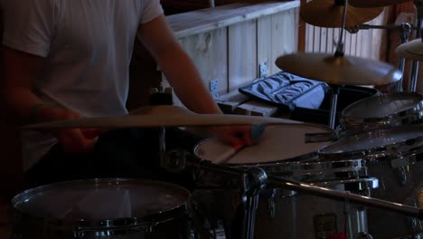 Man-with-White-T-Shirt-Playing-Rhythm-on-Drum-Set-Cymbals,-Indoor-Close-Up
