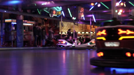 Happiness-People-having-fun-in-illuminated-leisure-park,riding-bumper-cars,close-up
