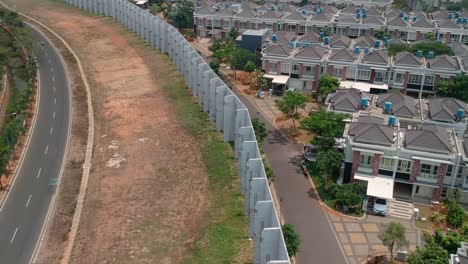 Aerial-top-shot-of-long-high-walls-separating-houses-and-road