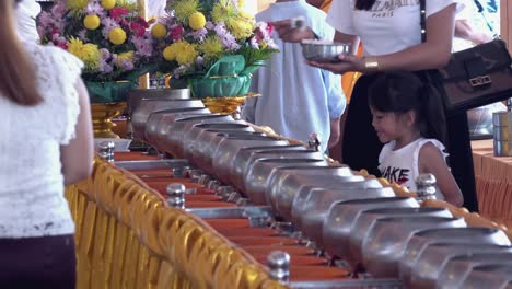 Menschen-Legen-Reis-In-Die-Mönchstöpfe-Im-Buddhistischen-Tempel