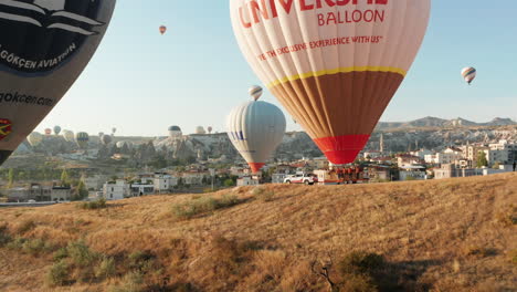 Aerial-close-up-of-hor-air-balloons-on-a-trailer-at-Goreme-Cappadocia,-Turkey,-preparing-for-flight