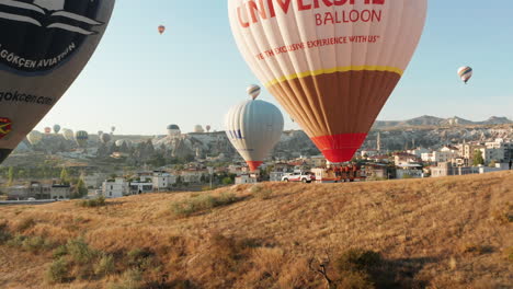 Primer-Plano-Aéreo-De-Globos-Aerostáticos-En-Un-Remolque-En-Goreme-Capadocia,-Turquía,-Preparándose-Para-El-Vuelo