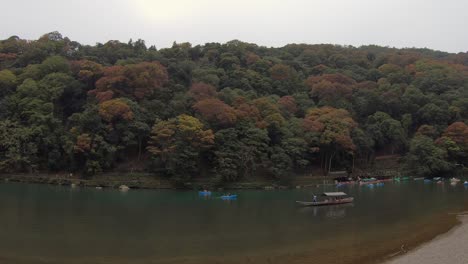 Katsura-River-tour-boat-is-poled-slowly-down-lazy-river,-Arashiyama