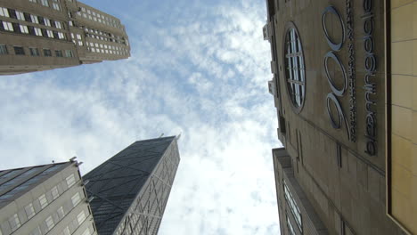 Vista-De-ángulo-Bajo,-Edificios,-Rascacielos,-Torre-Hancock-Y-Hermoso-Cielo-Azul-Y-Nubes,-Acercamiento-Suave