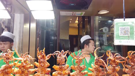 Xian,-China---July-2019-:-Meat,-snacks,-calamari-and-fried-baby-octopus-vendor-selling-food-on-the-street-in-the-Muslim-Quarter