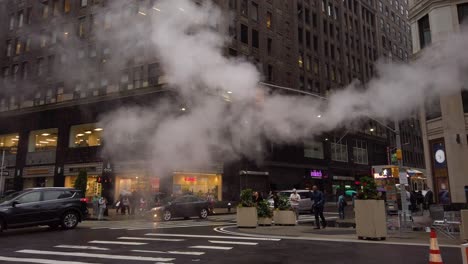 Vapor-Saliendo-De-Una-Tubería-De-Vapor-Naranja-Mientras-Los-Autos-Pasan-Y-La-Gente-Camina-En-La-Intersección-De-La-Calle-37-Oeste-Y-Broadway-En-Cámara-Lenta-De-120-Fps---Manhattan,-Ciudad-De-Nueva-York