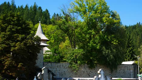 Tilt-up-shot-of-the-Voronet-graveyard-with-the-monastery-on-the-background-on-a-summer-day