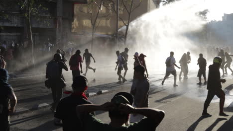 Vehículo-Blindado-De-La-Policía-Antidisturbios-Utiliza-Una-Manguera-Contra-Incendios-Para-Rociar-Agua-Y-Dispersar-A-Los-Alborotadores