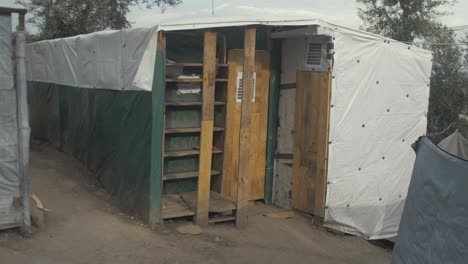 Woman-carrying-bottled-water-walk-by-makeshift-school-Moria-camp