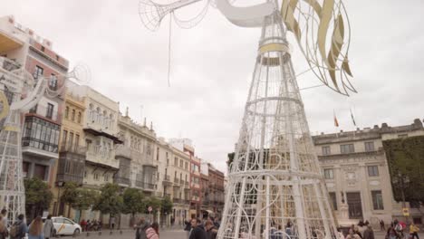 Inclinar-Hacia-Arriba,-ángeles-De-Navidad-Con-Trompetas-En-La-Plaza-De-San-Francisco,-Sevilla,-España