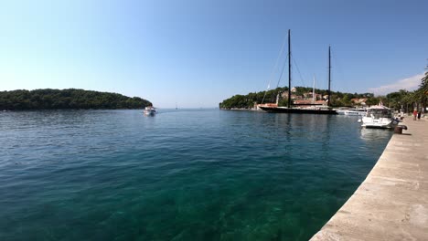 El-Barco-Se-Acerca-A-La-Ciudad-De-Cavtat,-Croacia-Con-Gente-A-Bordo-En-Un-Día-Soleado-De-Verano