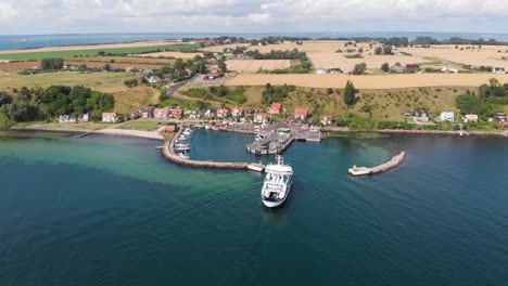 Aerial-view-forward-of-the-ferry-Uraniborg-arriving-in-the-harbor-of-Bäckviken-on-the-island-of-Ven-in-southern-Sweden-during-a-warm-summer-day-in-tourist-season