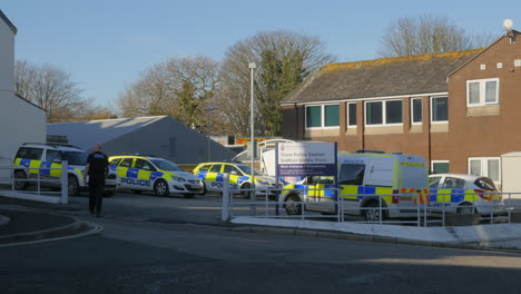 Policeman-walks-away-towards-his-vehicle-outside-Truro-Police-Station,-Cornwall
