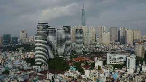 Imágenes-De-Drones-De-La-Tarde-Que-Vuelan-Hacia-El-Jardín-De-La-Ciudad-Sobre-Los-Tejados-Del-Distrito-De-Binh-Thanh-De-La-Ciudad-De-Ho-Chi-Minh,-Vietnam,-Con-Edificios-Clave-En-Un-Día-De-Contaminación-Atmosférica-Extrema-En-El-Sudeste-Asiático