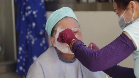 Taiwan-beautician-removing-facial-hair-by-threading-technique-procedure-on-Asian-female