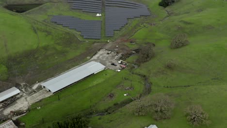 Aerial-flyover-of-solar-panels-powering-remote-cattle-farm-and-surrounding-community