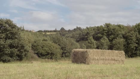 Hay-bales-in-farmers-field-wide-panning-shot