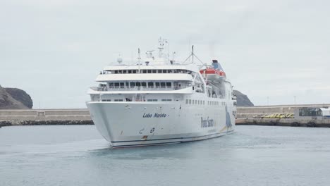 Gran-Barco-De-Pasajeros-Blanco-Maniobra-En-Las-Aguas-Del-Puerto-De-Porto-Santo-Por-Un-Muelle-De-Cemento-En-El-Puerto,-Portugal,-Retrato-Estático