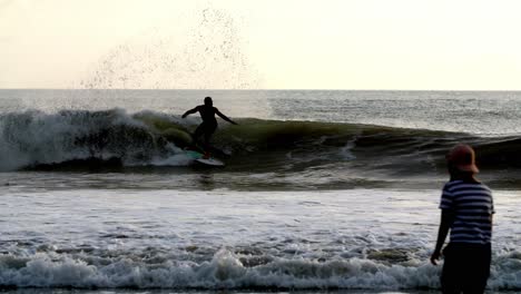 Surfista-Atrapando-Y-Montando-Una-Gran-Ola-Durante-La-Cámara-Del-Atardecer-Lo-Sigue,-Tiro-De-Seguimiento-Derecho