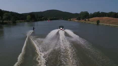 Aerial-tracking-view-of-water-skier-slaloming-behind-speed-boat