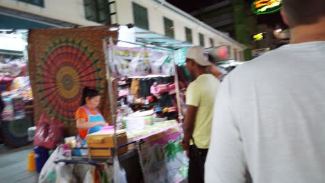 Handheld-scenes-of-the-tourists-are-walking-around-Khao-San-Road-at-night-time-famous-which-each-year-tourists-from-many-countries-came-to-visit-in-Bangkok,-Thailand