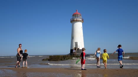 Tourist-family-playing-at-seaside-Landmark-Ayr-lighthouse