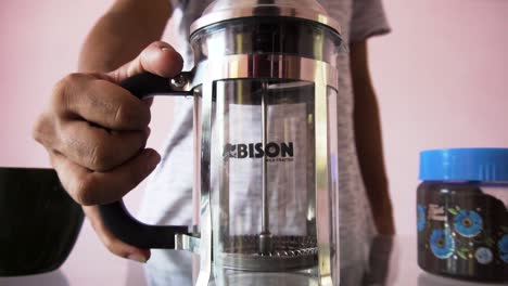 Man-making-coffee-with-French-press-coffee-maker-at-home