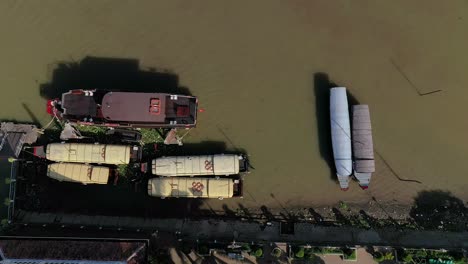 The-city-of-Can-Tho,-Vietnam-featuring-boats,-river,-and-architecture-from-drone-on-a-sunny-afternoon