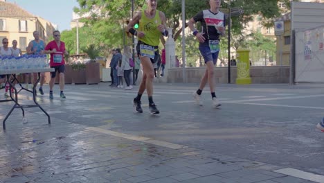 Runners-running-pass-water-station-in-a-marathon