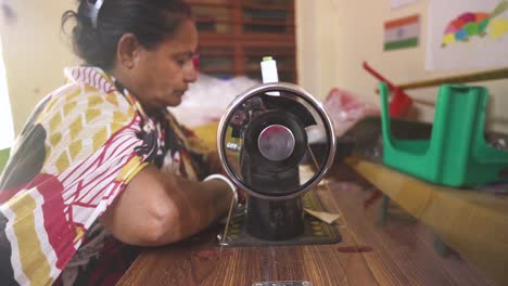 Rural-Indian-woman-stitching-cloth-using-sewing-machine-indoor-at-NGO