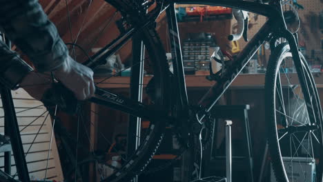 Bicycle-mechanic-installing-rear-wheel-on-road-bicycle