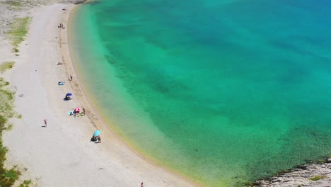 Antena-Adelante-Por-Encima-De-Los-Turistas,-Agua-De-Mar-Prístina,-Isla-De-Pag,-Croacia