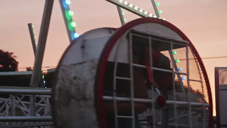 Children-riding-in-spinning-ride-at-small-town-carnival-in-Pennsylvania,-Pan-Left