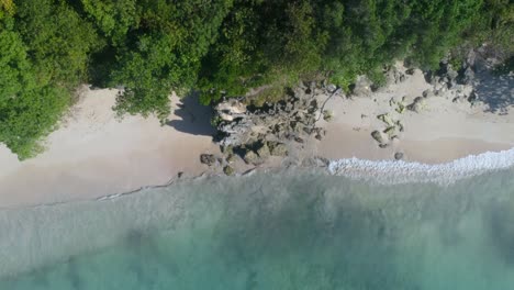 Aerial-shot-with-drone-on-a-beautiful-morning-on-the-shores-of-an-island-in-the-Caribbean,-watching-the-waves-of-the-beach-as-they-come-and-go-transmitting-peace