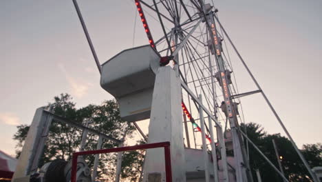 Ferris-wheel-spinning-at-sunset,-Dolly-Forward,-Wide-Shot,-Slow-Motion