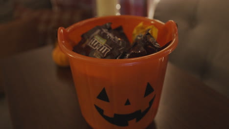 Slow-Motion-Close-Up-of-Candy-Falling-into-a-Halloween-Pumpkin-Pail