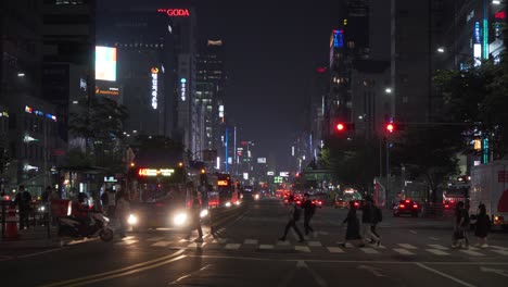 Ajetreada-Vida-Urbana-En-Las-Calles-De-La-Ciudad-Con-Peatones-Cruzando-La-Calle-En-Autobuses-Y-Tráfico-Por-La-Noche,-Estático,-Seúl,-Corea-Del-Sur