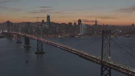 A-long-bridge-leading-to-a-large-city-at-night