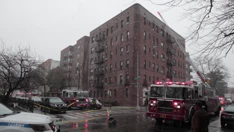 FDNY-firefighters-aiding-a-situation,-using-a-Fire-engine-ladder-to-reach-rooftop-of-building-in-New-York---Wide-shot