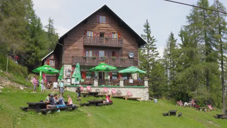 A-group-of-hikers-taking-a-rest-in-front-of-a-big-cabin-surrounded-by-forest