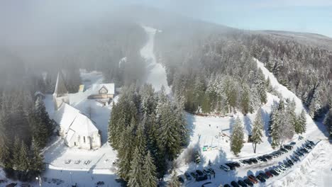 Aerial-view-of-ski-slopes,-Trije-kralji-winter-resort-on-Pohorje,-Slovenia,-few-people-due-covid-restrictions-are-able-to-enjoy-outdoor-activities