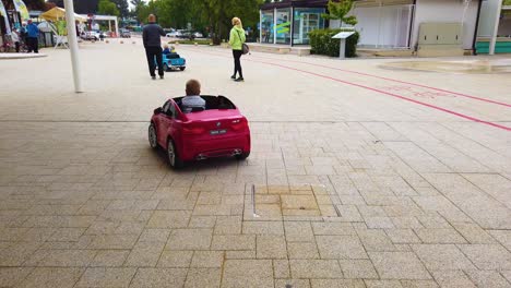 A-kid-riding-in-an-electric-motor-toy-car-on-the-street-having-fun