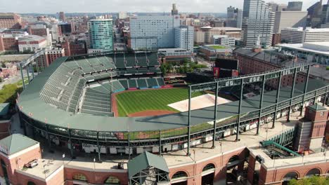 Baltimore-Orioles,-Camden-Yards,-home-of-MLB-team,-turf-covered,-being-prepared-for-game,-city-skyline-in-distance,-Hilton-Hotel,-University-of-Maryland
