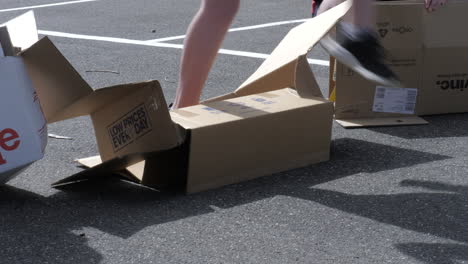 Child-Squashing-Down-A-Cardboard-Box-For-Recycling-At-School