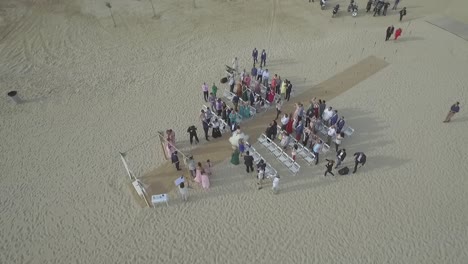 Bride-and-Groom-Walking-Down-the-Aisle-at-Beach-Wedding-Ceremony,-Top-Down,-Aerial-Circling